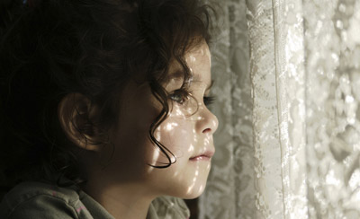 a girl with curly hair looking out the window, soft light filtering through lace curtains, creating a serene atmosphere