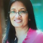 Portrait of South-East Asian woman with long hair and glasses smiling