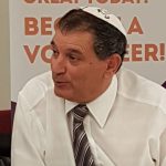 Middle-aged man in collared shirt with tie and white kippah