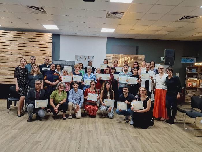 Group of adults posing for photo while holding certificates